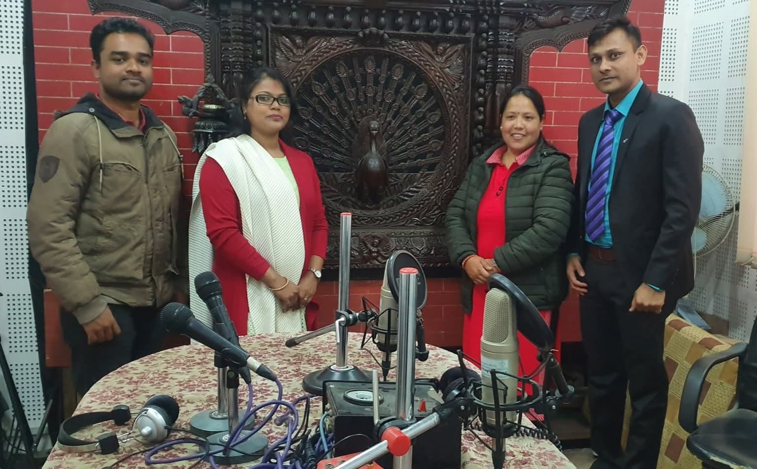 Community radio team standing together in the studio after a broadcast