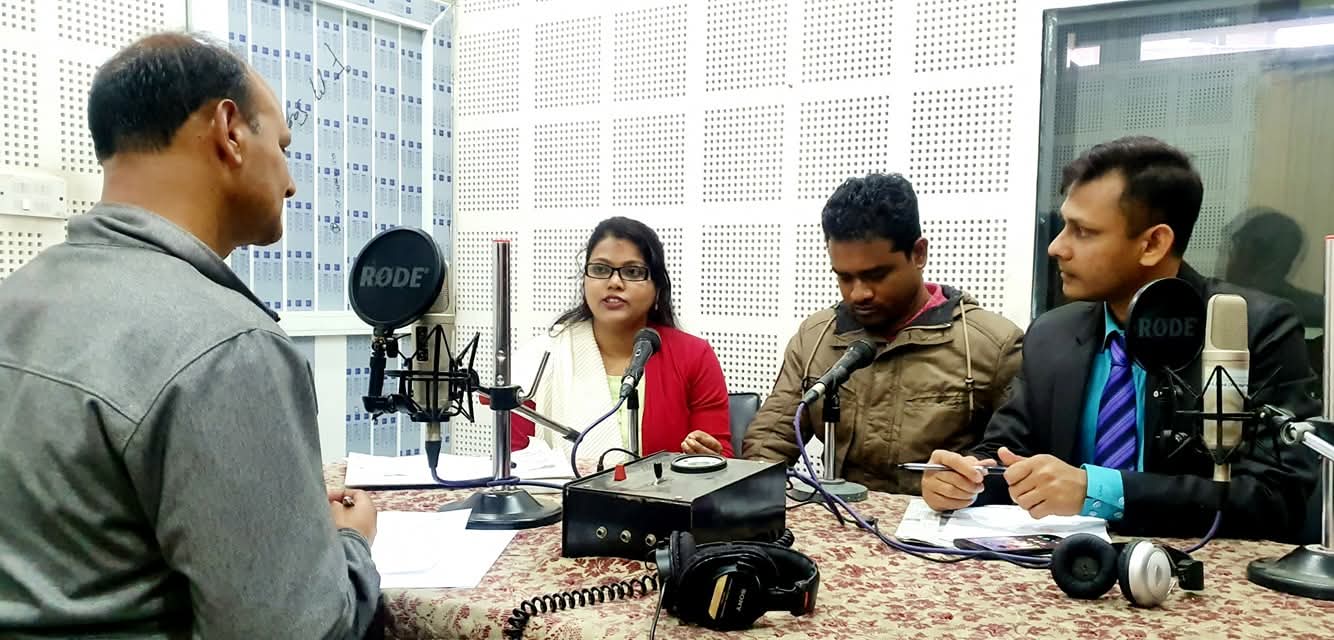 Live talk show recording with four participants around studio microphones in Nepal